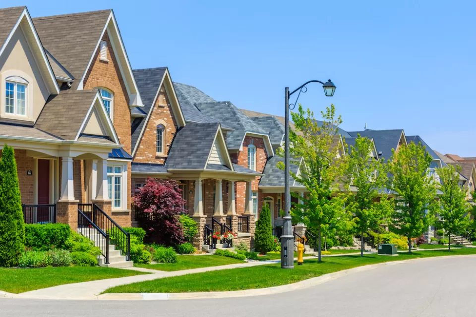 Row of single-family houses on suburban street on sunny day.